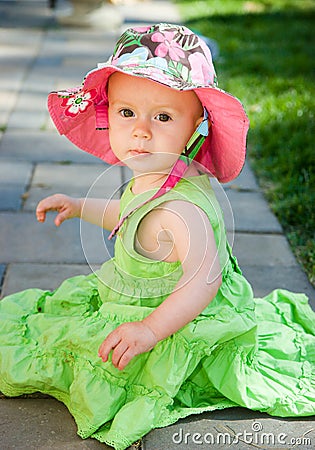Girls Dress on Beautiful Baby Girl Sits On Ground In Green Sun Dress And Hat