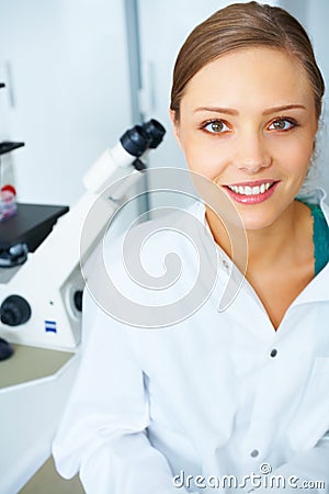 Female Student Sitting By A Microscope In The Lab