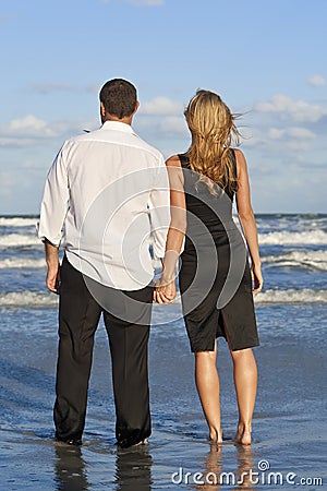 couple holding hands on beach. MAN AND WOMAN COUPLE HOLDING