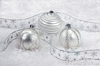 Three White And Silver Christmas Ornaments On Snow