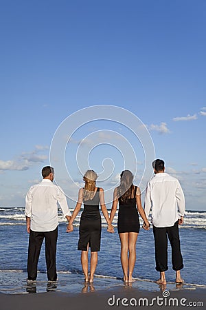 couple holding hands on beach. TWO COUPLES, HOLDING HANDS ON